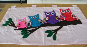 A vibrant and colorful group of Appliqued owls for a wall hanging 